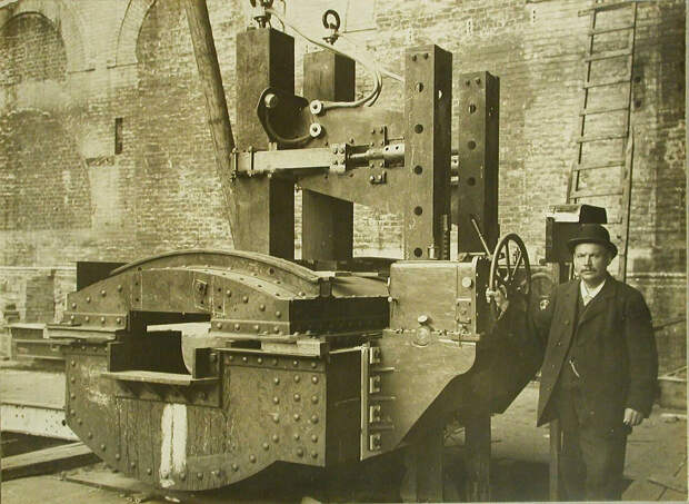 14. Заводской служащий у станины печи, установленной в одном из цехов. 20 октября 1909
