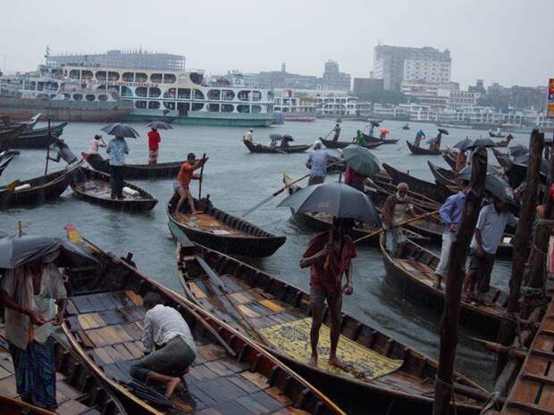 Такси в виде лодок пересекают реку Буриганга, ведущую в Садар Гхат – главные водные ворота Дакки, которые обеспечивают транспортную связь с одним из самых плотно заселённых городов мира. Столица Дакка, находящаяся достаточно низко над уровнем моря, является одним из городов, наиболее подверженных угрозе поднятия уровня моря.