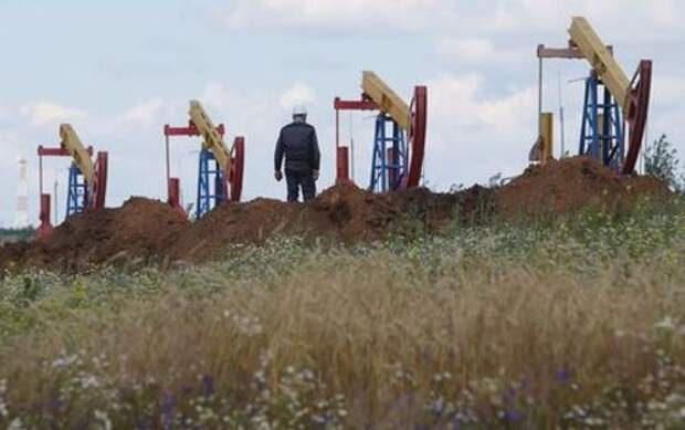 A worker stands in front of pump jacks at the Ashalchinskoye oil field owned by Russia's oil producer Tatneft near Almetyevsk, in the Republic of Tatarstan, Russia, July 27, 2017. Picture taken July 27, 2017. REUTERS/Sergei Karpukhin