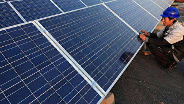 Рабочий ремонтирует солнечные батареи на заводе в Китае. Архивное фото