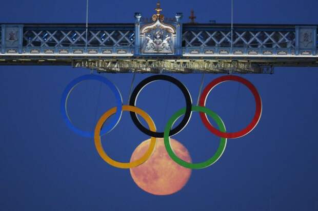 The full moon rises through the Olympic Rings hanging beneath Tower Bridge during the London 2012 Olympic Games on August 3, 2012. (REUTERS / Luke MacGregor)