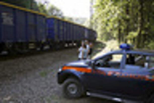 A railway security guards' car is seen next to people observing a cargo train travelling in an area where a Nazi train is believed to be at, in Walbrzych, southwestern Poland August 30, 2015. Poland said on Friday it was almost certain it had located the Nazi train rumored to have gone missing near the close of World War Two loaded with guns and jewels. Polish authorities started looking for the train this month, tipped off by a German and a Pole who said through lawyers that they had found it in the southwestern district of Walbrzych and expected 10 percent of the value of the findings as a reward. REUTERS/Kacper Pempel - RTX1QB42