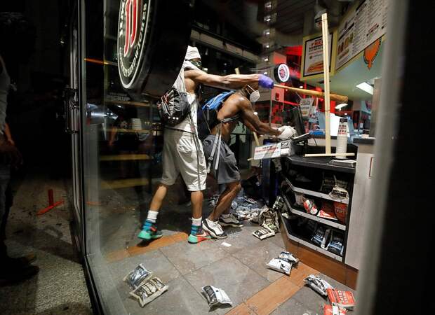 Разъяренные люди бьют витрины, машины, грабят торговые центры и нападают на полицейских. Фото: REUTERS