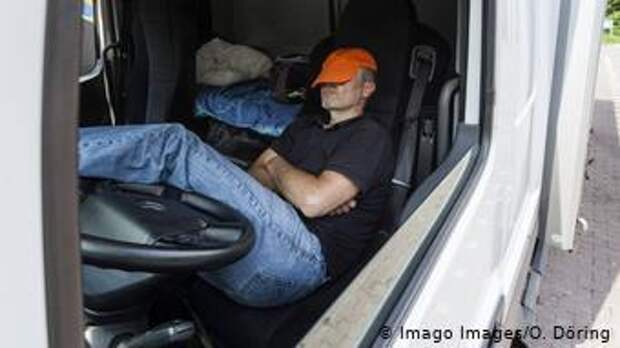 Водитель отдыхает в кабине грузовика