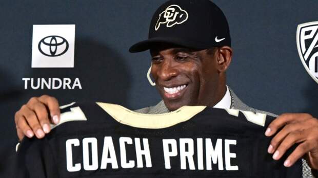 Colorado football coach Deion Sanders holding Coach Prime jersey