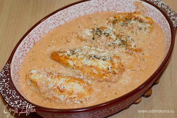 Заливаем соусом куриные грудки, посыпаем оставшимся сыром и запекаем при 180°С 30 минут.