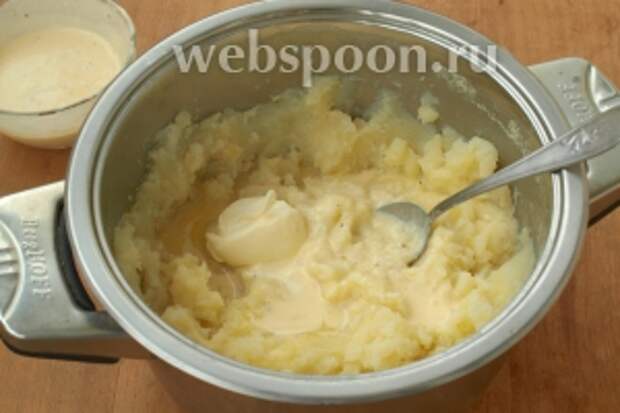 С картофеля слить воду, размять картофелемялкой. Добавить в картофель половину яично-сметанной смеси и половину сливочного масла, хорошо перемешать.