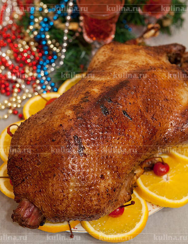 Готовую птицу выложить на блюдо, украсить ломтиками свежего апельсина, вишней и зеленью - подать к столу.  