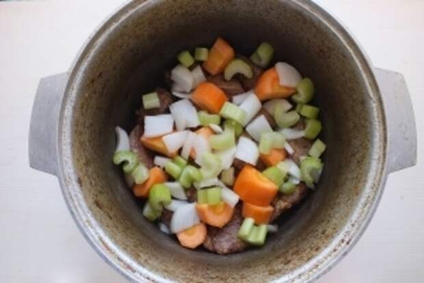 Нарежьте кусочками лук и сельдерей. Крупно нарежьте морковь и добавьте к мясу.