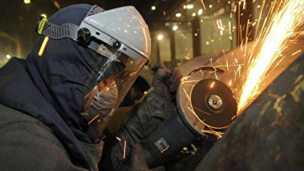 Рабочий во время обработки изделий на сталелитейном производстве