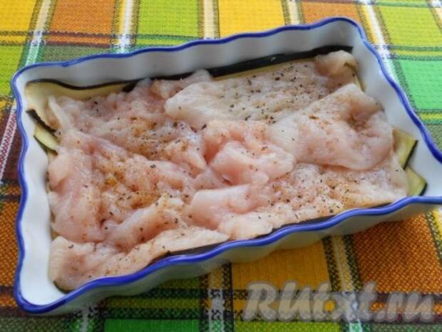 На баклажаны поместить пласты куриного филе, отбитого молоточком. Посолить немного, посыпать специями и перцем.