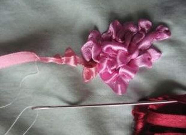 Можно перейти к дальнейшему вышивания цветочков. Для этого делайте такие же стежки, а потом узелок на изнаночной стороне ткани для каждого цветочка. Формируйте цветы так, чтобы они вписывались в нарисованный контур сирени.