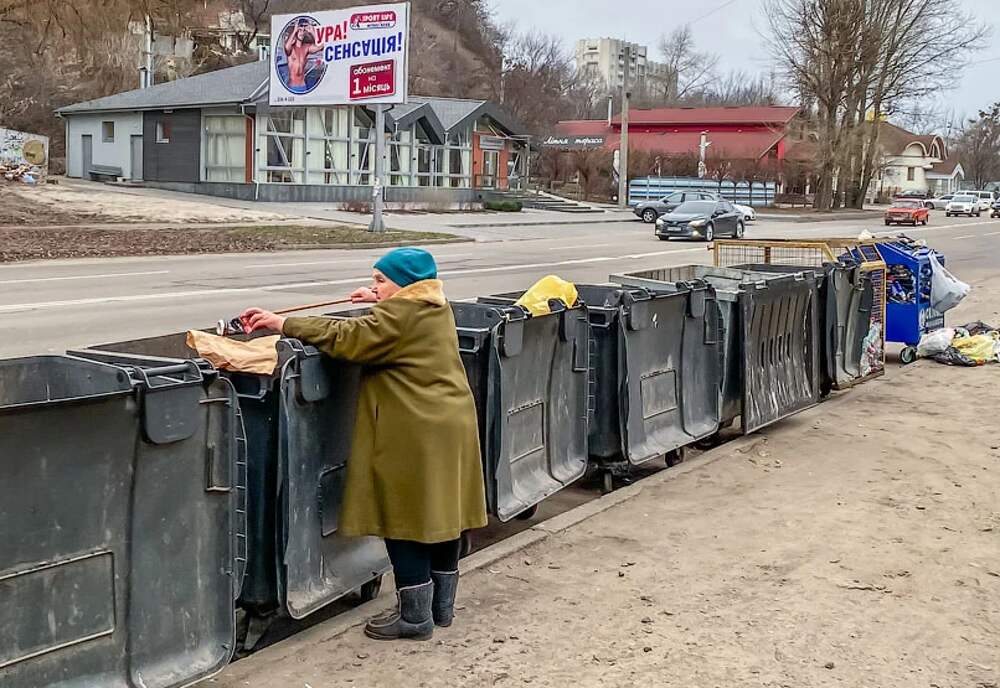 Копаются в мусорках. Нищие украинские пенсионеры роются в мусорке.
