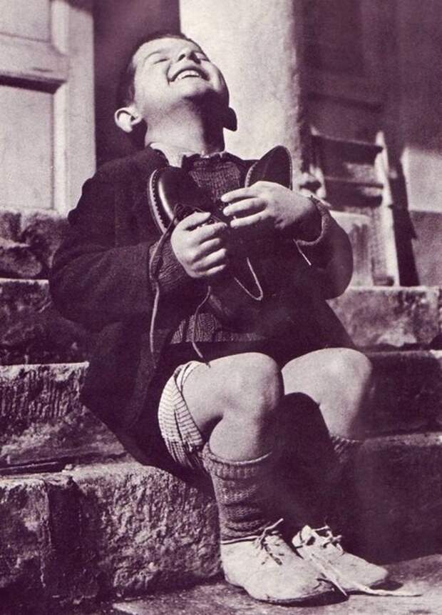 12. Мальчик в детском приюте получает в подарок новые ботинки, Австрия, 1946 г. архивные снимки, архивные фото, исторические кадры, исторические фото, исторические фотографии, история, старые фото, черно-белые снимки