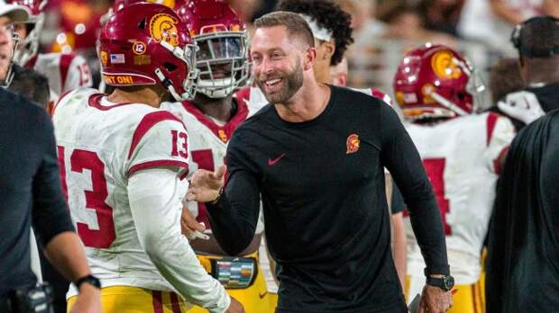 USC analyst Kliff Kingsbury congratulates QB Caleb Williams on the sidelines.