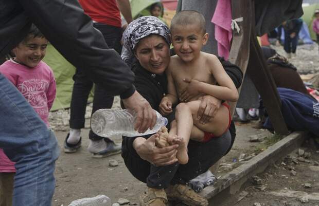 Сирийская беженка моет новорожденного в луже… Снимок, облетевший весь мир! (ФОТО)