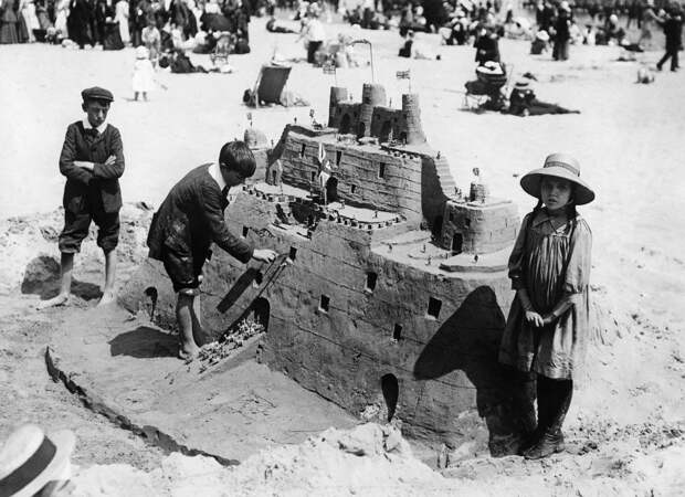 Дети строят песочный замок. Уэймут, Англия, примерно 1913 г. 100 лет назад, 20 век, архивные снимки, архивные фотографии, пляж, пляжный отдых, черно-белые фотографии, чёрно-белые фото