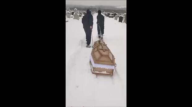 Гроб целый километр тянут на веревках по заваленным снегом тропинкам кладбища