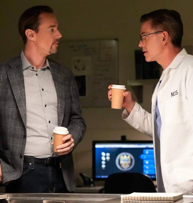 McGee and Jimmy chatting while holding coffee