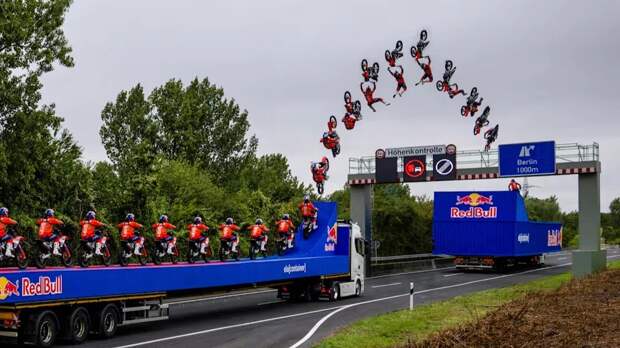 Мотогонщик прыгнул между движущимися грузовиками