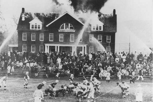 Дети играют в футбол перед горящей школой