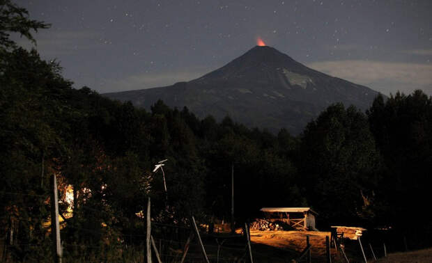 Сумерки над городом Пукон на фоне вулкана Вильяррика.