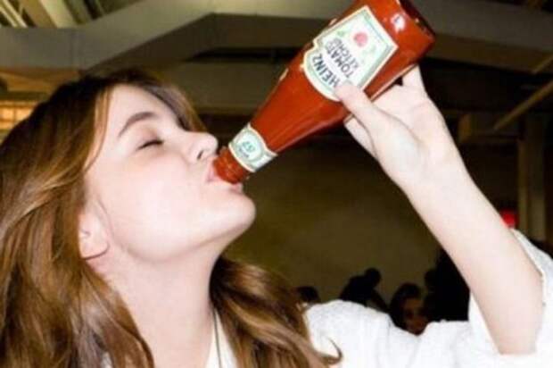 Девушка пьет кетчуп
