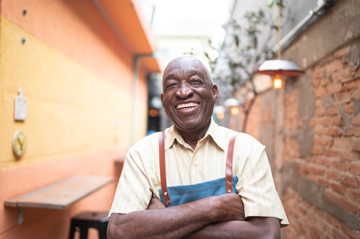 Someone standing and smiling in a garden.