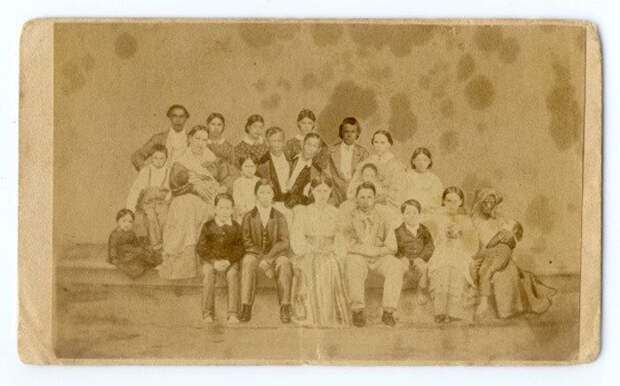 Семейный портрет Чанга, Энга, их жен и 18 из 21 детей, а также Грейс Гейтс, одна из 33 рабов на плантации Банкеров. 1860-е.