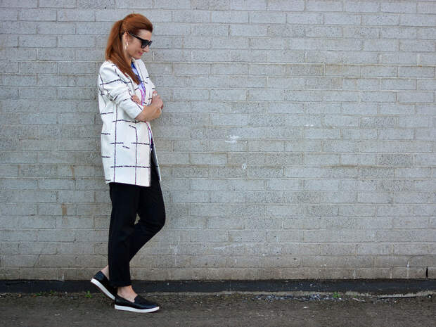 Mixed patterns: Windowpane check coat, graphic t-shirt, black trousers and slip on sneakers