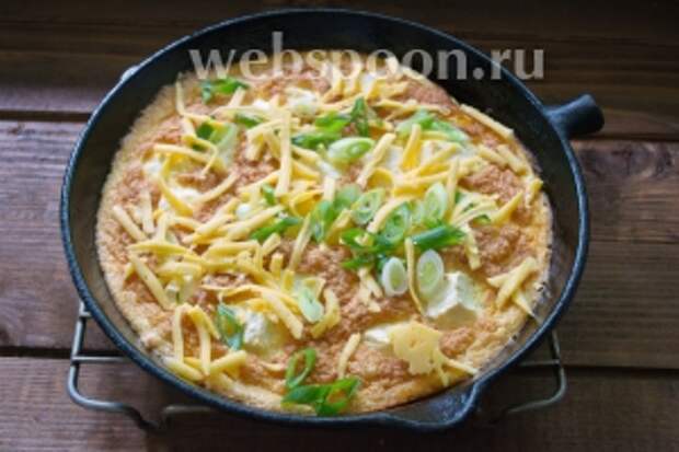 Готовый горячий омлет достать из духовки. Посыпать зелёным луком и натёртым на тёрку сыром. Готово.