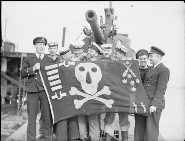 A few of the ratings of HMS THUNDERBOLT with the boat%27s %27Jolly Roger%27 ensign on deck beneath the 4 inch gun. She is in Blyth after returning from the Mediterranean. %28Small%29.jpg