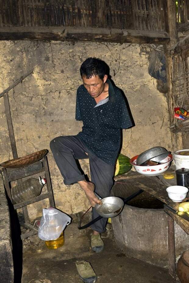 14 Aug 2015, Chongqing Municipality, China --- Chen Xingyin, a 48-year-old farmer who lost his arms at seven, uses his feet to bail water at his home in Tongxin village, Fengdu county, Chongqing, China, 14 August 2015. A 48-year-old farmer from Chongqing municipality who lost his arms in an accident when he was young has made headlines this week after his touching story of perseverance came to the attention of Chinese netizens. Chen Xingyin is from Tongxin village, Fengdu county, Chongqing municipality. He lost his arms in an electrical accident when he was only 7 years old. Despite this obstacle, Chen has managed to do his best to fend for himself. He can do most work on his own, including farming, cooking and feeding his goats.Chen is the youngest son from a six-member family. Since 2014, he has taken care of his bed-ridden 88-year-old mother, who began suffering from bronchitis five years ago. He cooks her --- Image by © Imaginechina/Corbis