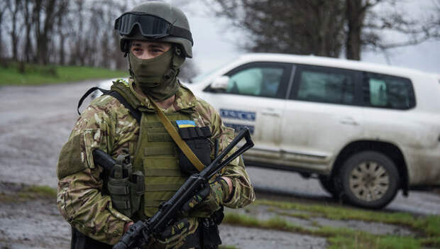 Украинский военный возле машины наблюдателей ОБСЕ возле деревни Широкино, Восточная Украина Украинский военный возле машины наблюдателей ОБСЕ возле деревни Широкино, Восточная Украина
