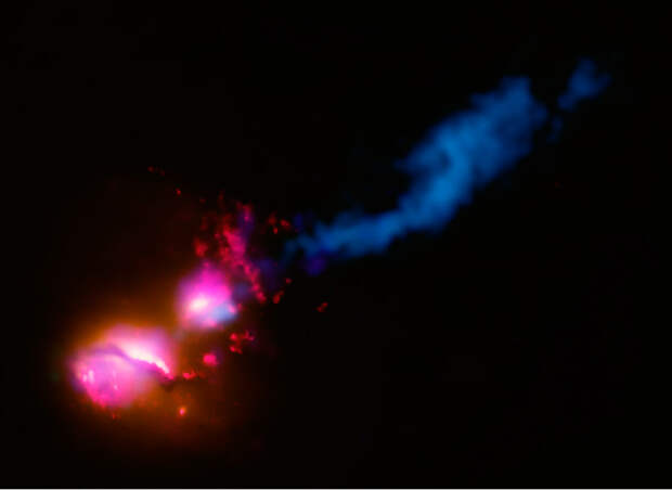 Мощный поток частиц из сверхмассивной черной дыры, ударивший по расположенной рядом галактике