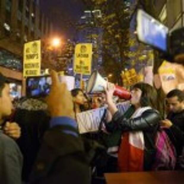 Karina Garcia, of the ANSWER Coalition, uses a megaphone to lead demonstrators in a chant during a protest against Republican presidential candidate Donald Trump's hosting "Saturday Night Live" in New York, Saturday, Nov. 7, 2015. Despite a 40-year history of lampooning politicians while inviting some to mock themselves as on-air guests, booking a presidential candidate to host the NBC sketch-comedy show is almost unprecedented. (AP Photo/Patrick Sison)
