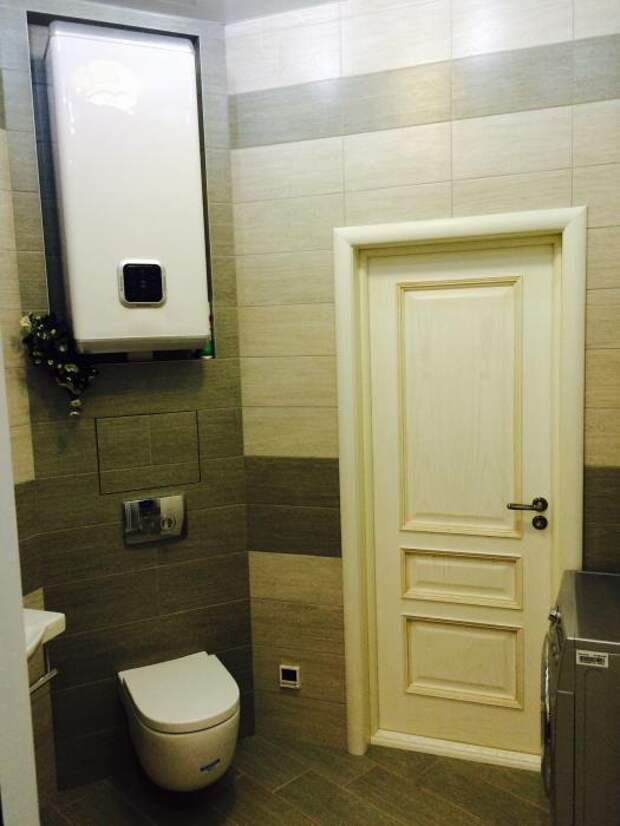 Навесной унитаз, бойлер, белая дверь в ванной комнате