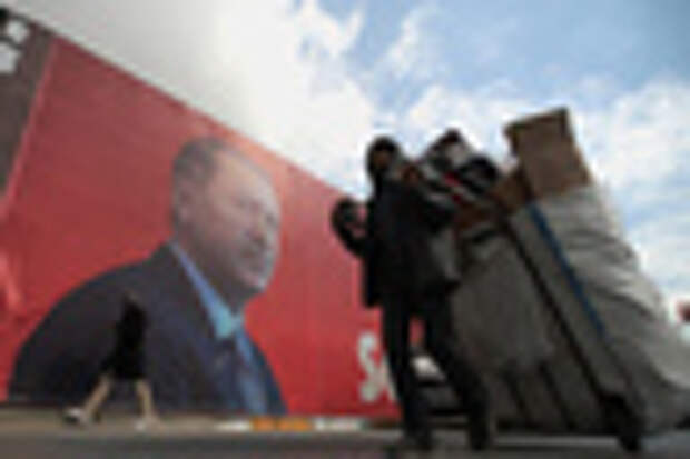 epa05900747 A woman walks in front of a giant picture of Turkish President Recep Tayyip Erdogan, in Istanbul, Turkey, 10 April 2017. A referendum on the constitutional reform in Turkey will be held on 16 April. The reform, passed by Turkish parliament on 21 January, would change the country's parliamentarian system of governance into a presidential one, which the opposition denounced as giving more power to Turkish president Recep Tayyip Erdogan. EPA/SEDAT SUNA Scene 