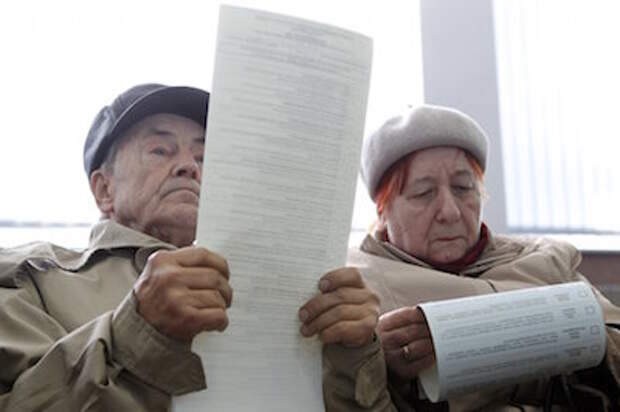 People look through their ballots during a parliamentary election at a polling station in Kiev, October 26, 2014. Ukrainians voted on Sunday in an election that is likely to install a pro-Western parliament and strengthen President Petro Poroshenko's mandate to end separatist conflict in the east, but may fuel tension with Russia. REUTERS/Valentyn Ogirenko (UKRAINE - Tags: POLITICS ELECTIONS)