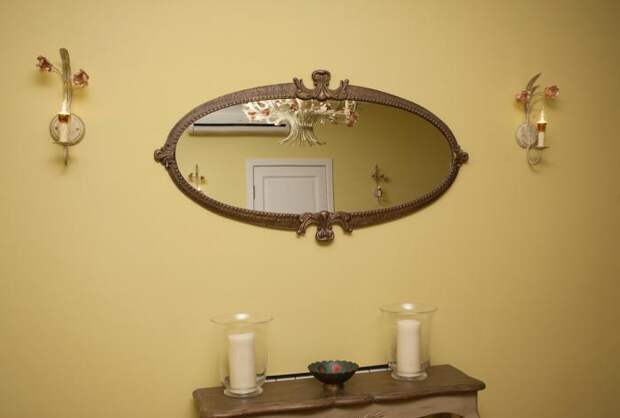Консольный столик, подсвечники со свечами, овальное зеркало в раме