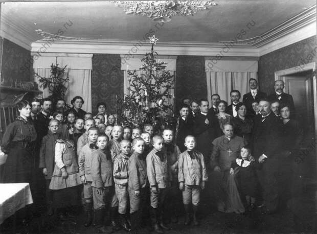 1916. Воспитанники приютов на елке, организованной Петроградским обществом вспомощения бедным семьям поляков, пострадавшим от войны. В центре – епископ Цепляк 1916. Воспитанники приютов на елке, организованной Петроградским обществом вспомощения бедным семьям поляков, пострадавшим от войны. В центре – епископ Цепляк