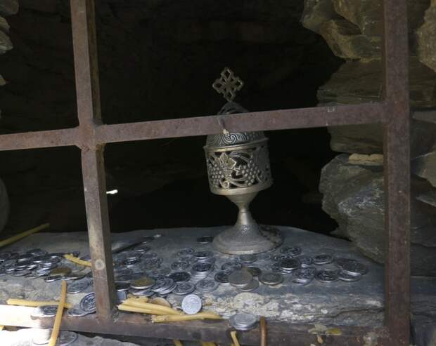 Offerings of coins and candles at the crypts of Anatori, Georgia. Photo by Paul Salopek.