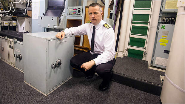 Дэниел Мартин, командир HMS Vigilant, рядом с сейфом, в котором хранятся последние инструкции премьер-министра, на борту подводной лодки класса Vanguard HMS Vigilant 