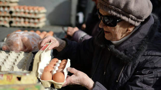 Пенсионерка покупает яйца на городской продовольственной ярмарке в Новосибирске. Архивное фото