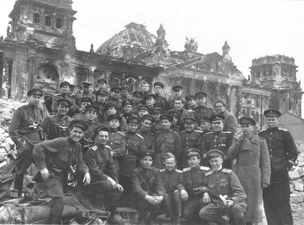 Писатель, драматург, военный корреспондент Всеволод Вишневский (третий справа, второй ряд) с товарищами на ступенях рейхстага, май 1945 года.