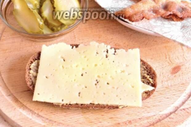 Сверху на хлеб положить ломтик сыра.