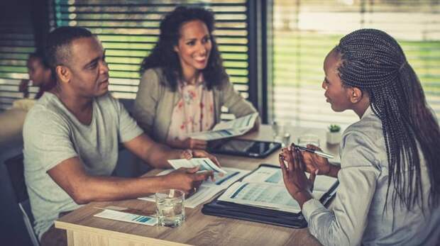 Financial professional talks to couple over paperwork