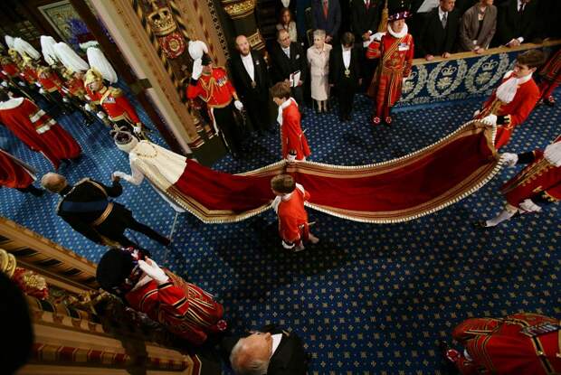Платье было создано для Елизаветы II в 1953 году для коронации, с тех пор его несколько раз перешивали. На фото: Елизавета II с супругом принцем Филипом направляются в зал заседаний палаты лордов, 2014 год