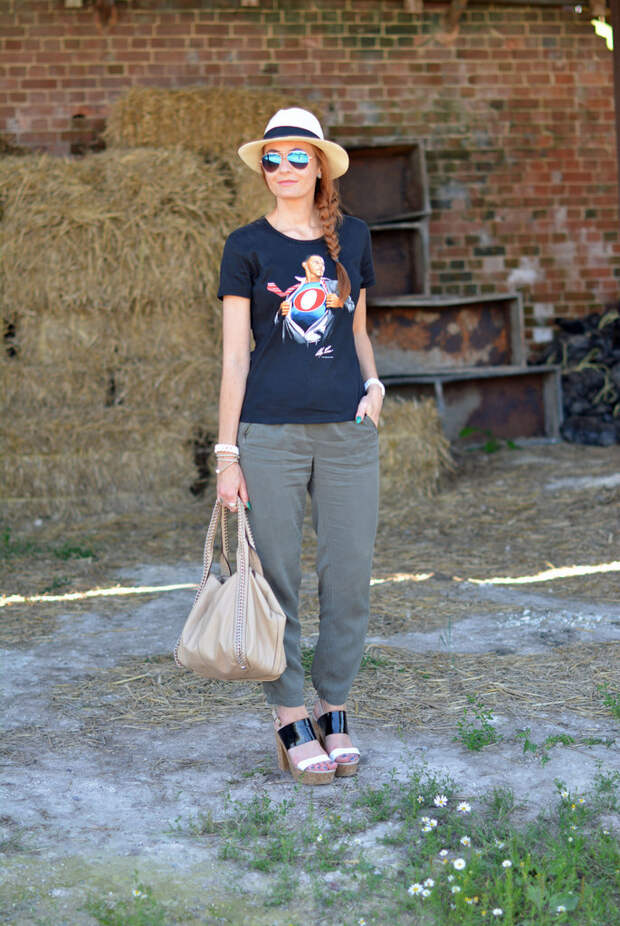 Black graphic tee with Panama hat, khaki track pants, strappy platforms