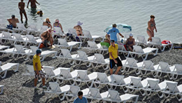 Работники Приморского пляжа в Ялте расставляют лежаки для отдыхающих. Архивное фото